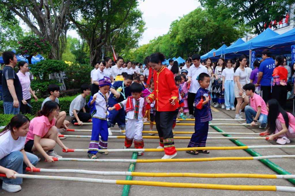 大手牵小手——体验非遗竹竿舞。